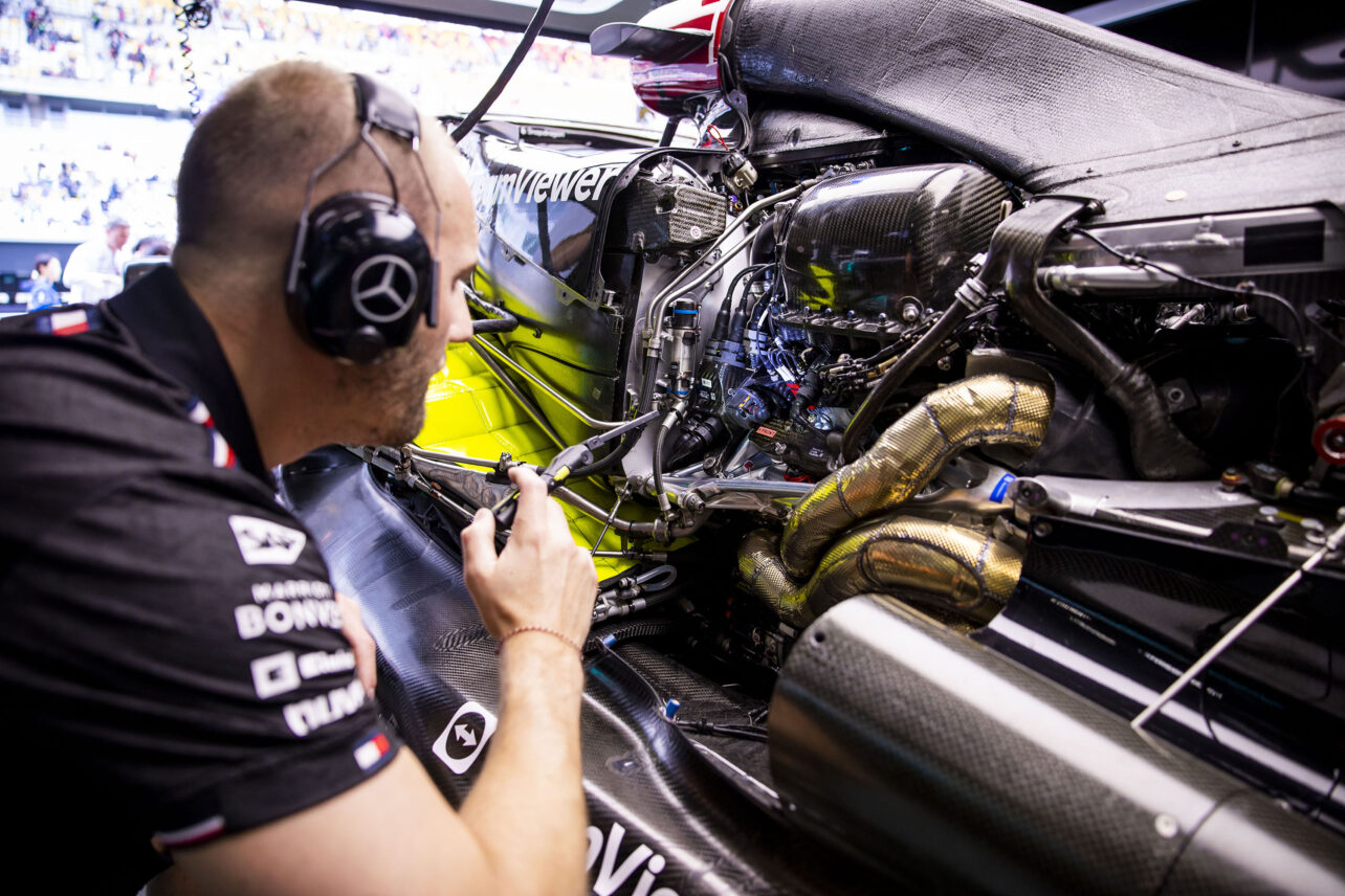 Mercedes AMG F1 Team Engineer inspecting the power unit in the garage during a race weekend